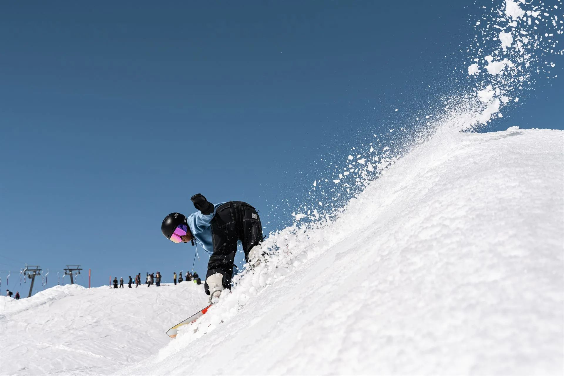 Zazi Betari, Indonesian Snowboard Girl, spraying a powder slash